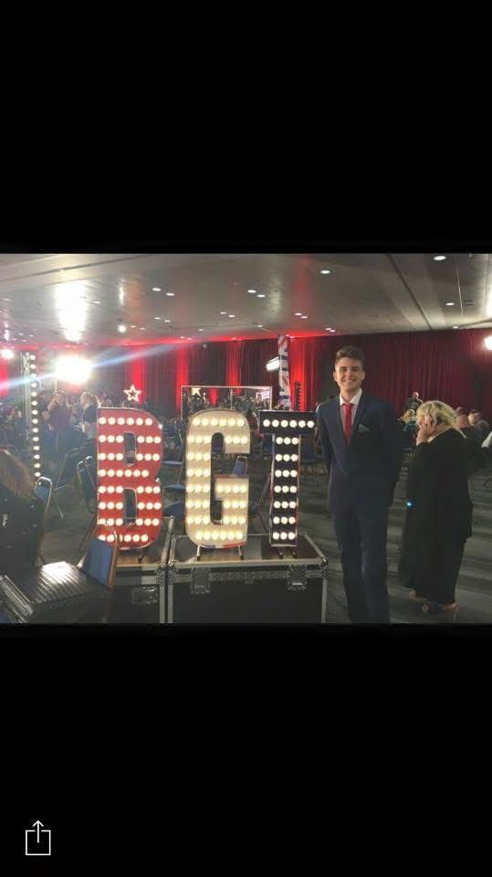 George Berryman standing backstage near a Britain's Got Talent sign.